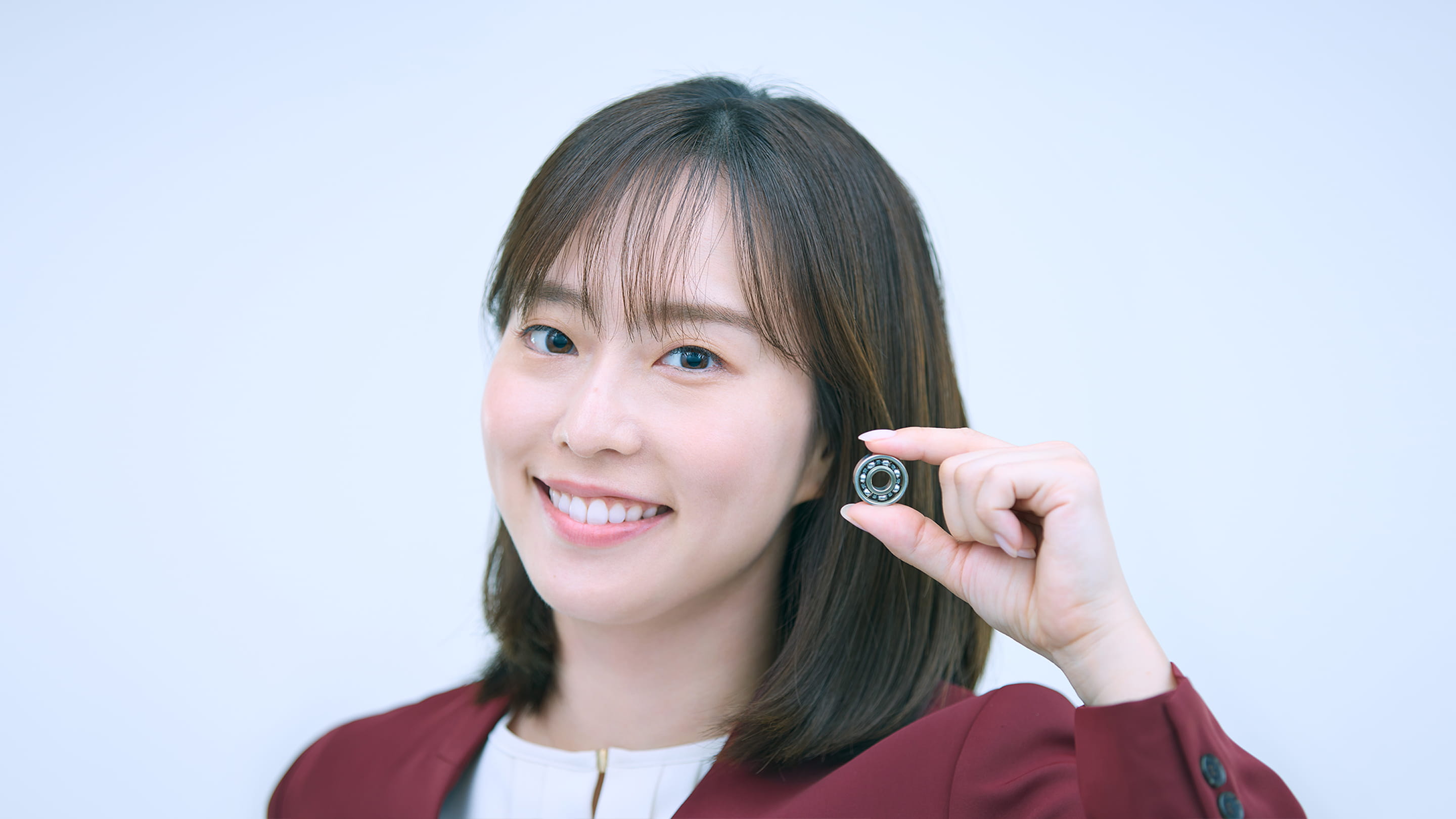 女性がミネベアミツミのベアリングを持っている。